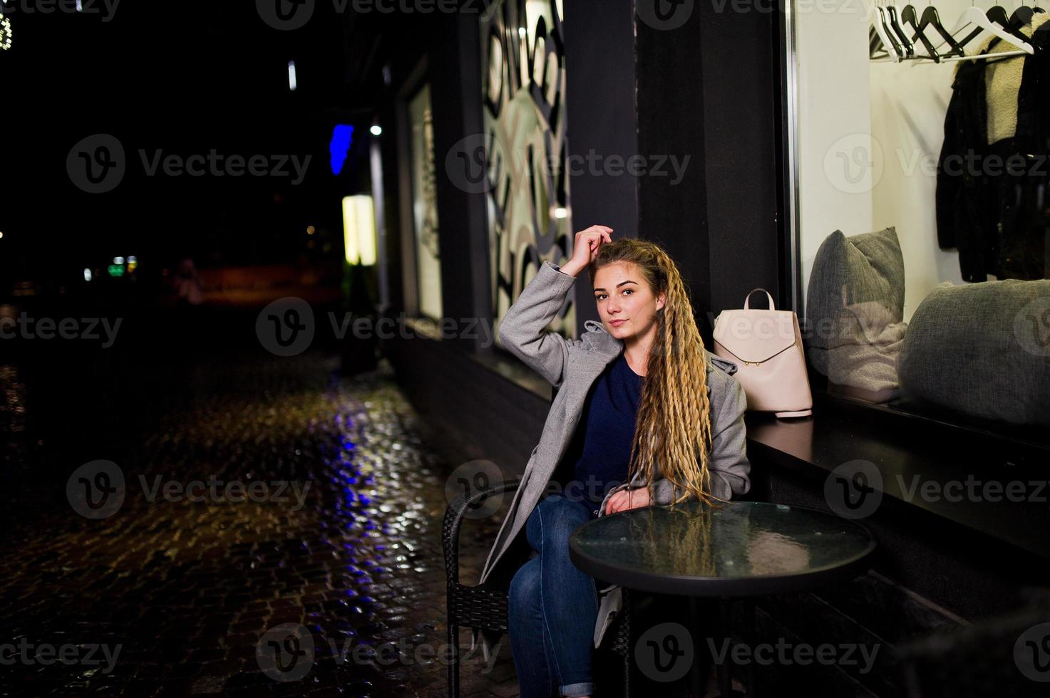 ragazza con i dreadlocks che cammina di notte per la strada della città. foto