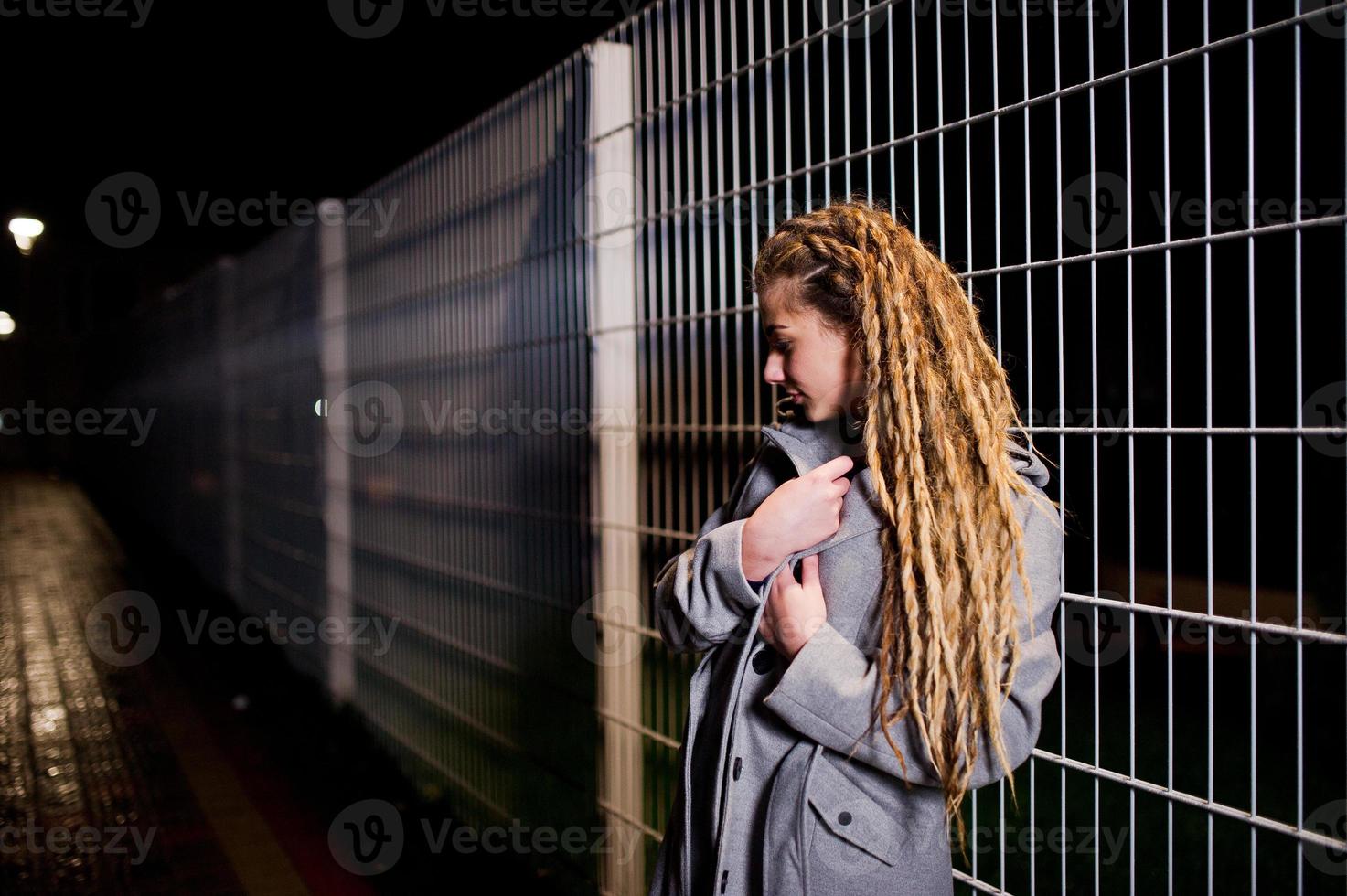 ragazza con i dreadlocks che cammina di notte per la strada della città. foto