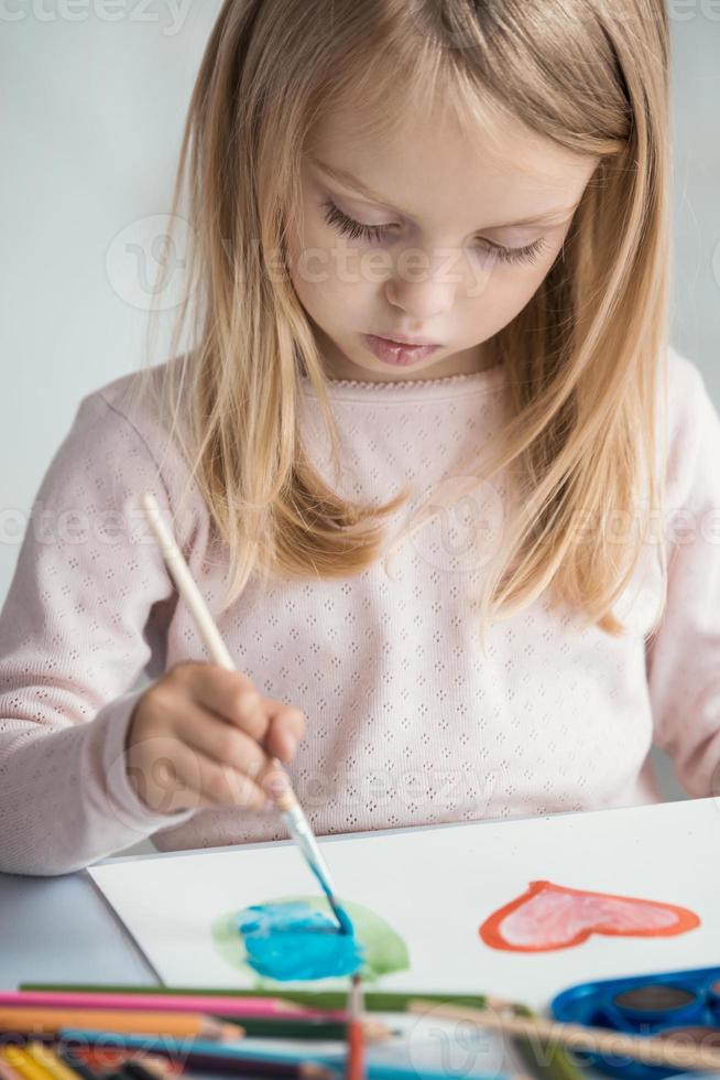 la bambina disegna con i pennelli foto