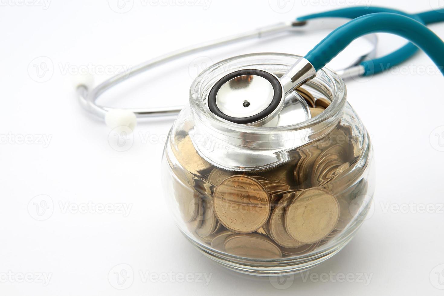 stetoscopio con monete nel risparmio, concetto finanziario foto