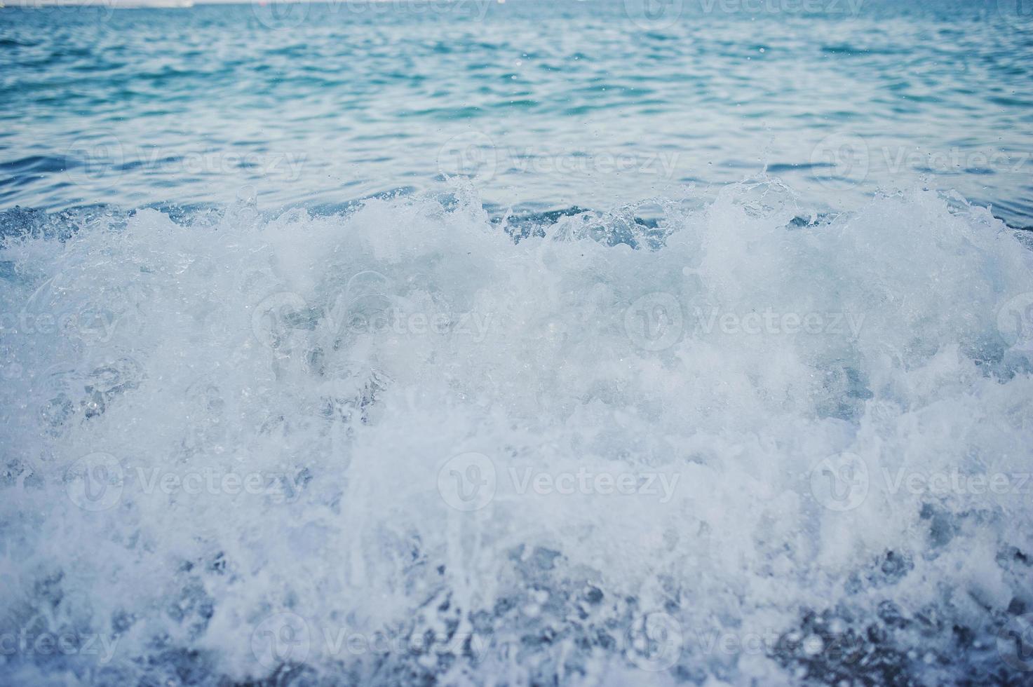 foto ravvicinata delle onde che si infrangono sulla spiaggia di sabbia.