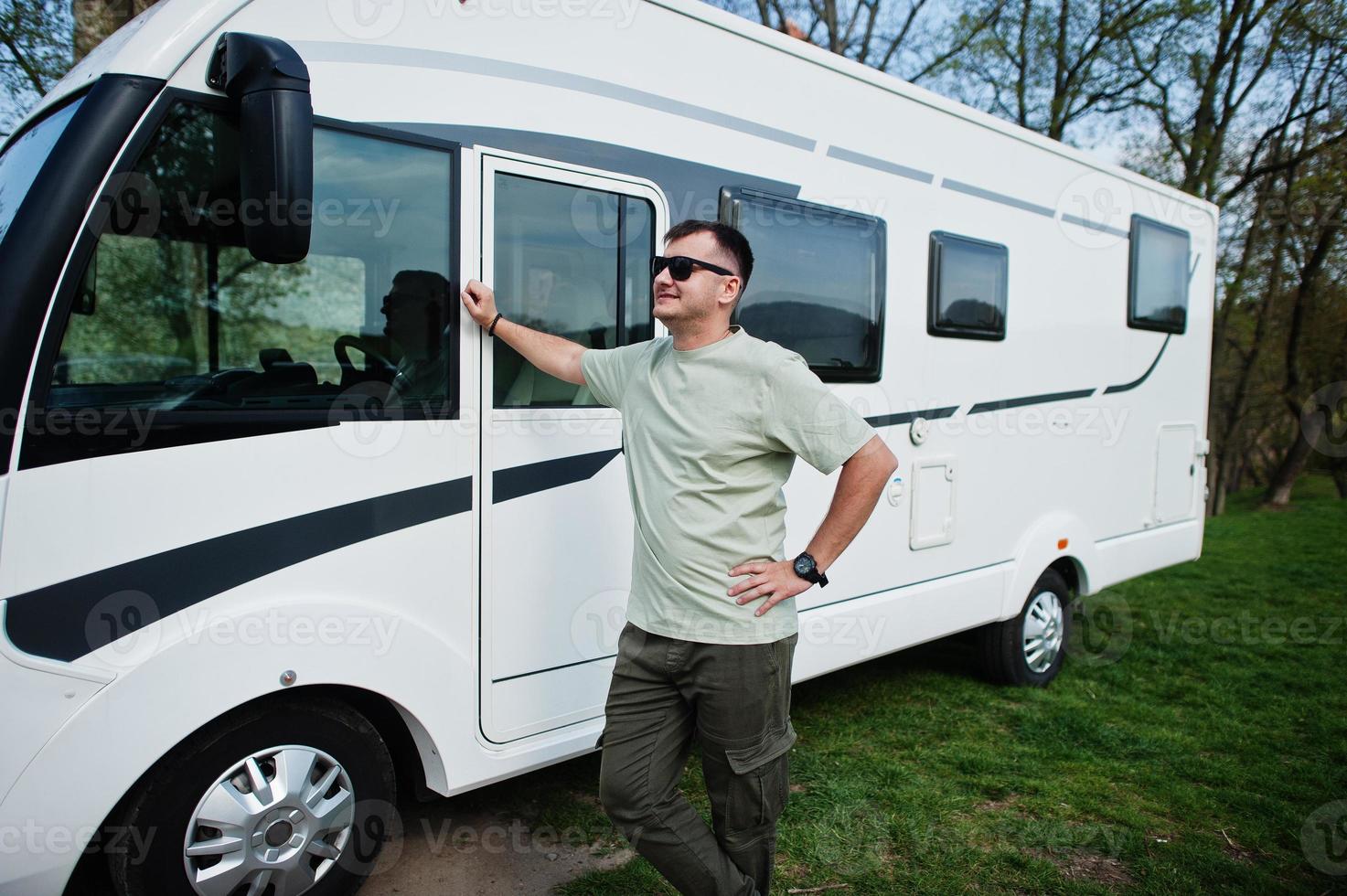 l'uomo con gli occhiali da sole viaggia in camper camper. foto