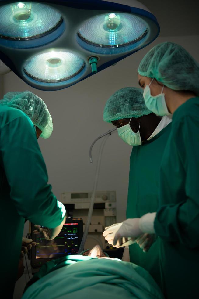 professore di medicina in cardiologia e un'équipe di medici in sala operatoria sottoposti a trapianto cardiaco foto