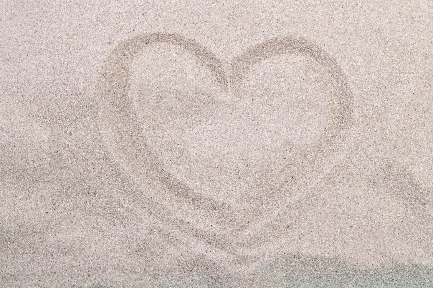 costa del mare. cuore di iscrizione sulla sabbia della spiaggia foto
