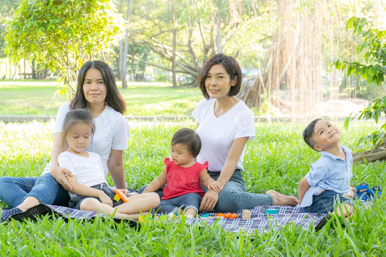 bella giovane famiglia di genitori asiatici picnic ritratto nel parco, bambino o bambini e madre amano felici e allegri insieme in estate al giardino, concetto di stile di vita. foto