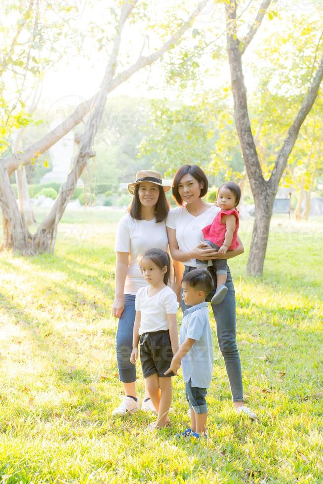bella giovane famiglia di genitori asiatici picnic ritratto nel parco, bambino o bambini e madre amano felici e allegri insieme in estate al giardino, concetto di stile di vita. foto