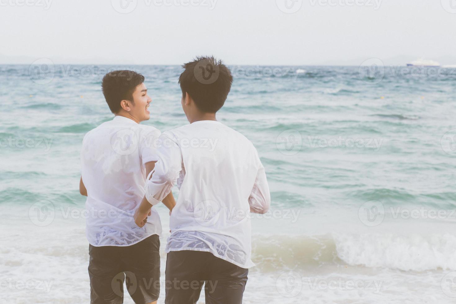 giovane coppia asiatica omosessuale che corre con allegro insieme sulla spiaggia in estate, turismo gay in asia per il tempo libero e relax con felicità in vacanza al mare, concetto legale lgbt. foto