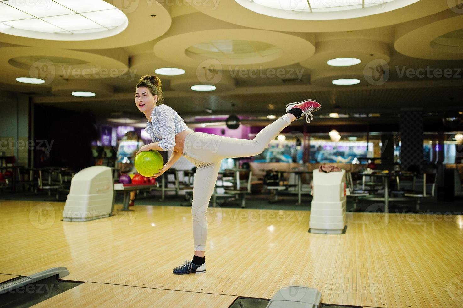 ragazza con palla da bowling sul vicolo giocato al bowling club. foto