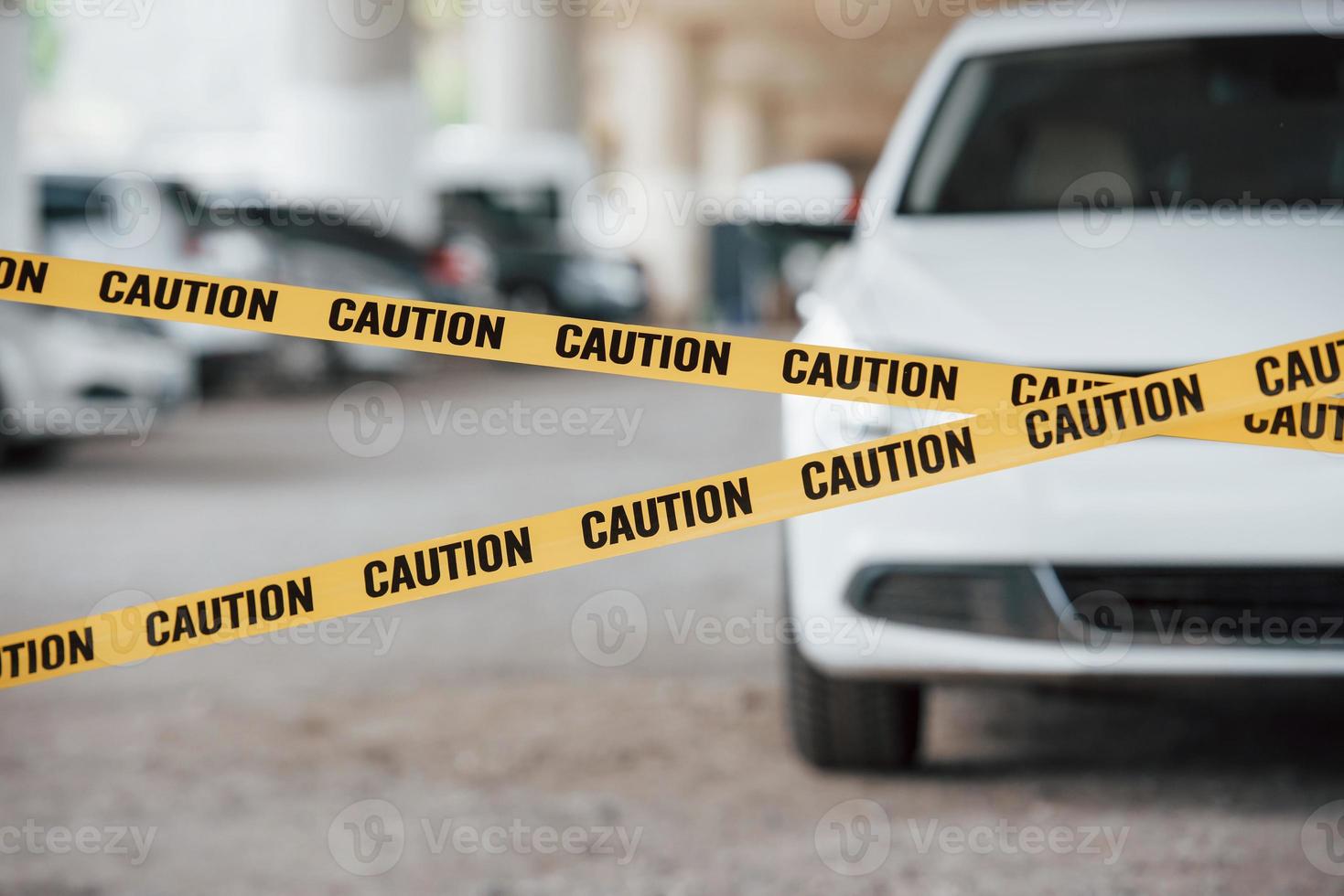 davanti al moderno veicolo di lusso. nastro di avvertenza giallo vicino al parcheggio durante il giorno. scena del crimine foto