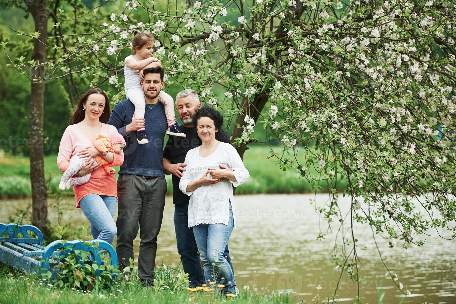 foto di famiglia. ritratto a figura intera di persone allegre in piedi all'aperto insieme vicino al lago