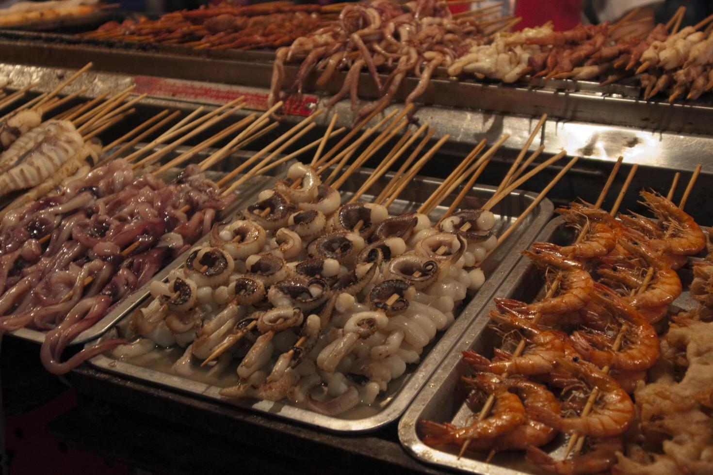 Spiedini assortiti con pesce fresco e frutti di mare. mercato di strada in Cina foto