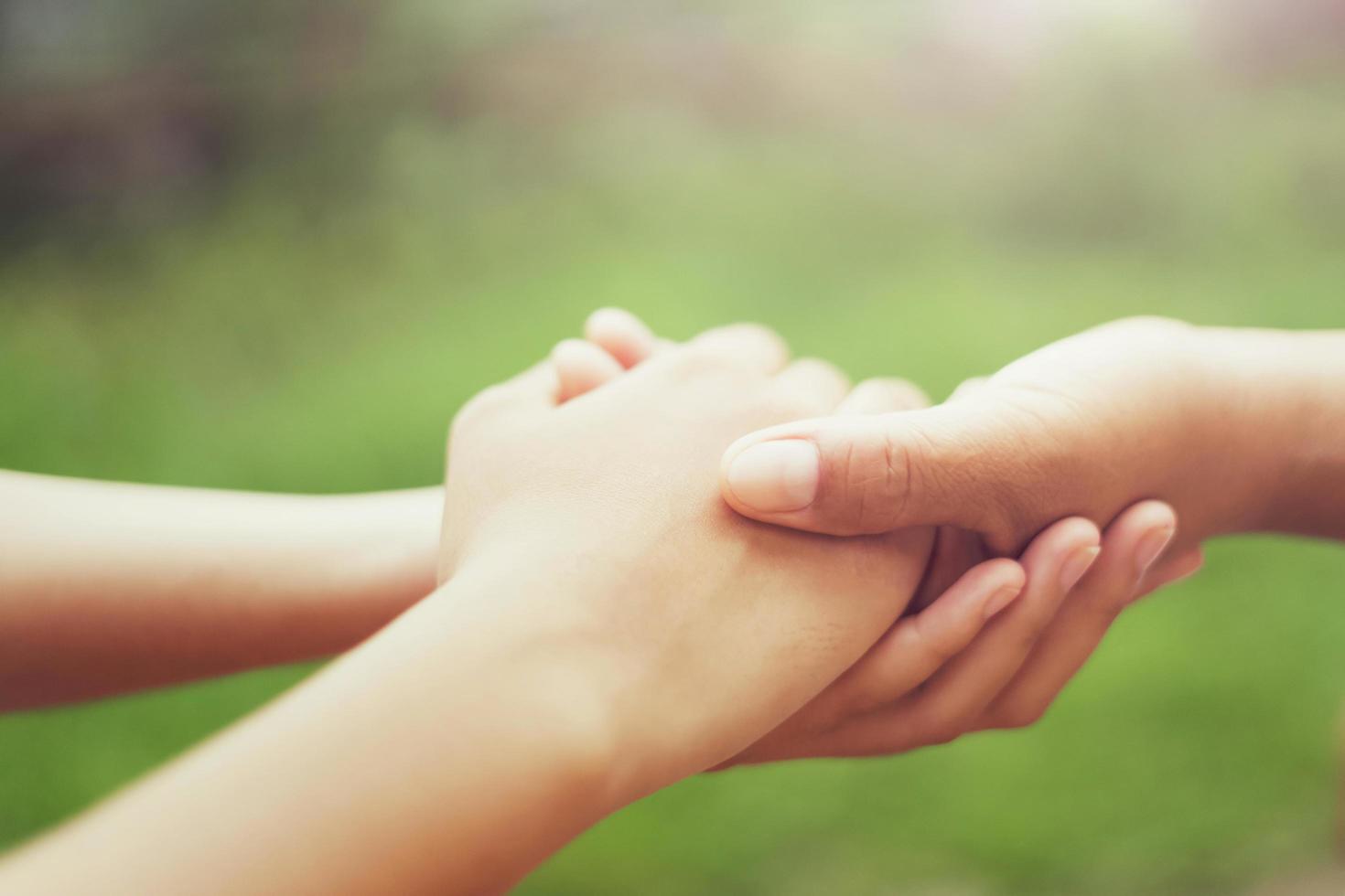 persone anziane e giovani che tengono la mano con la luce del sole. concetto potere di speranza foto