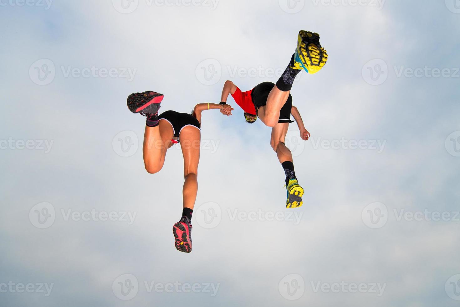 coppia di sportivi fanno un salto nel cielo mano nella mano foto