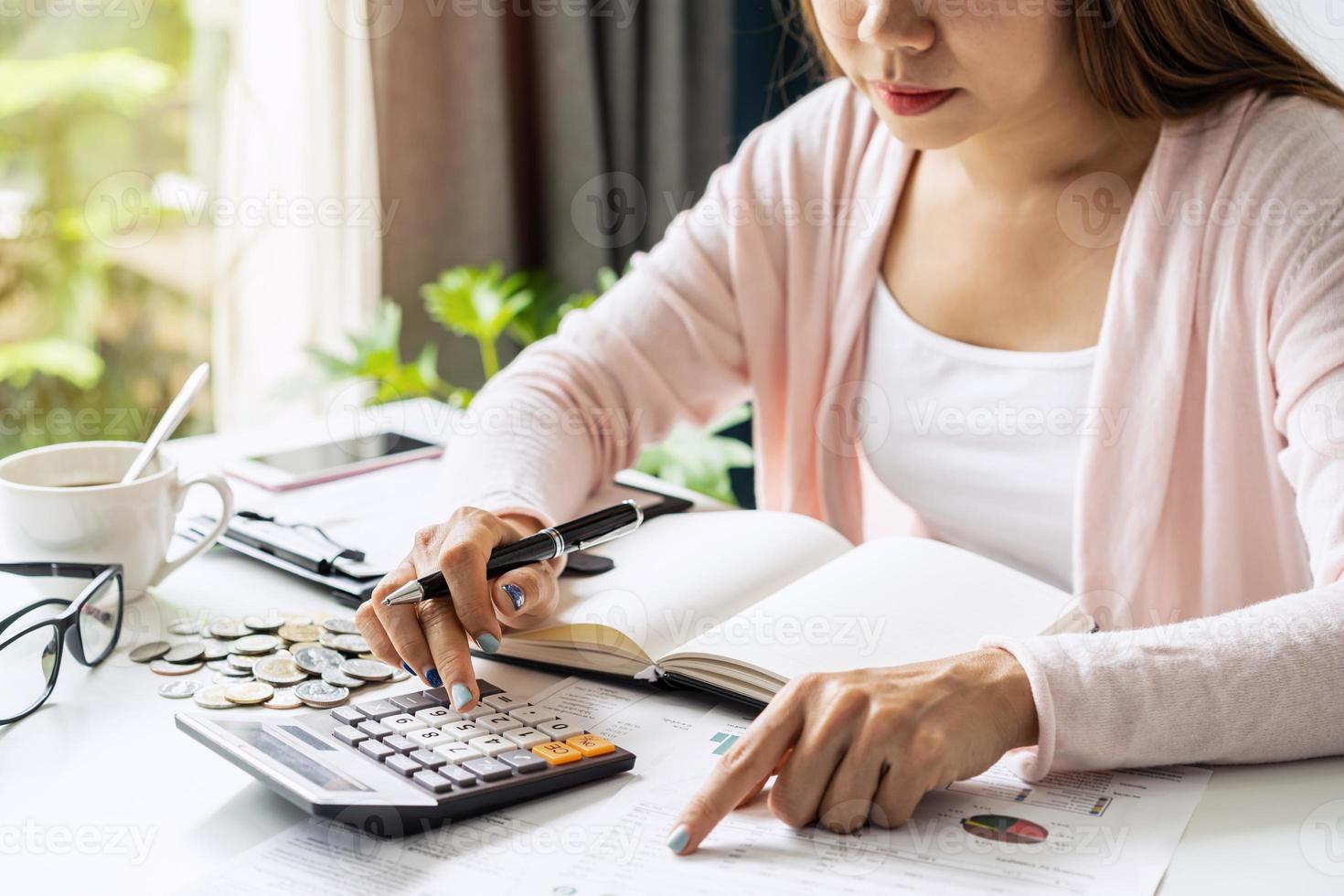 giovane donna stressata che calcola le spese mensili della casa, le tasse, il saldo del conto bancario e il pagamento delle bollette della carta di credito, il reddito non è sufficiente per le spese. foto