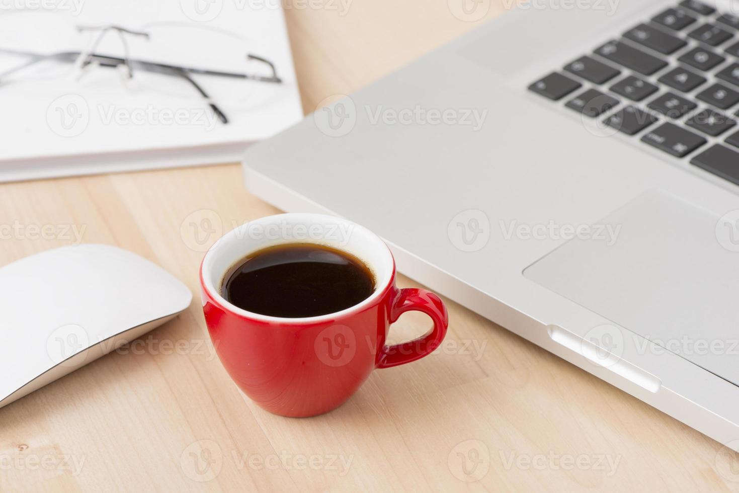 tazza di caffè e laptop in ufficio foto