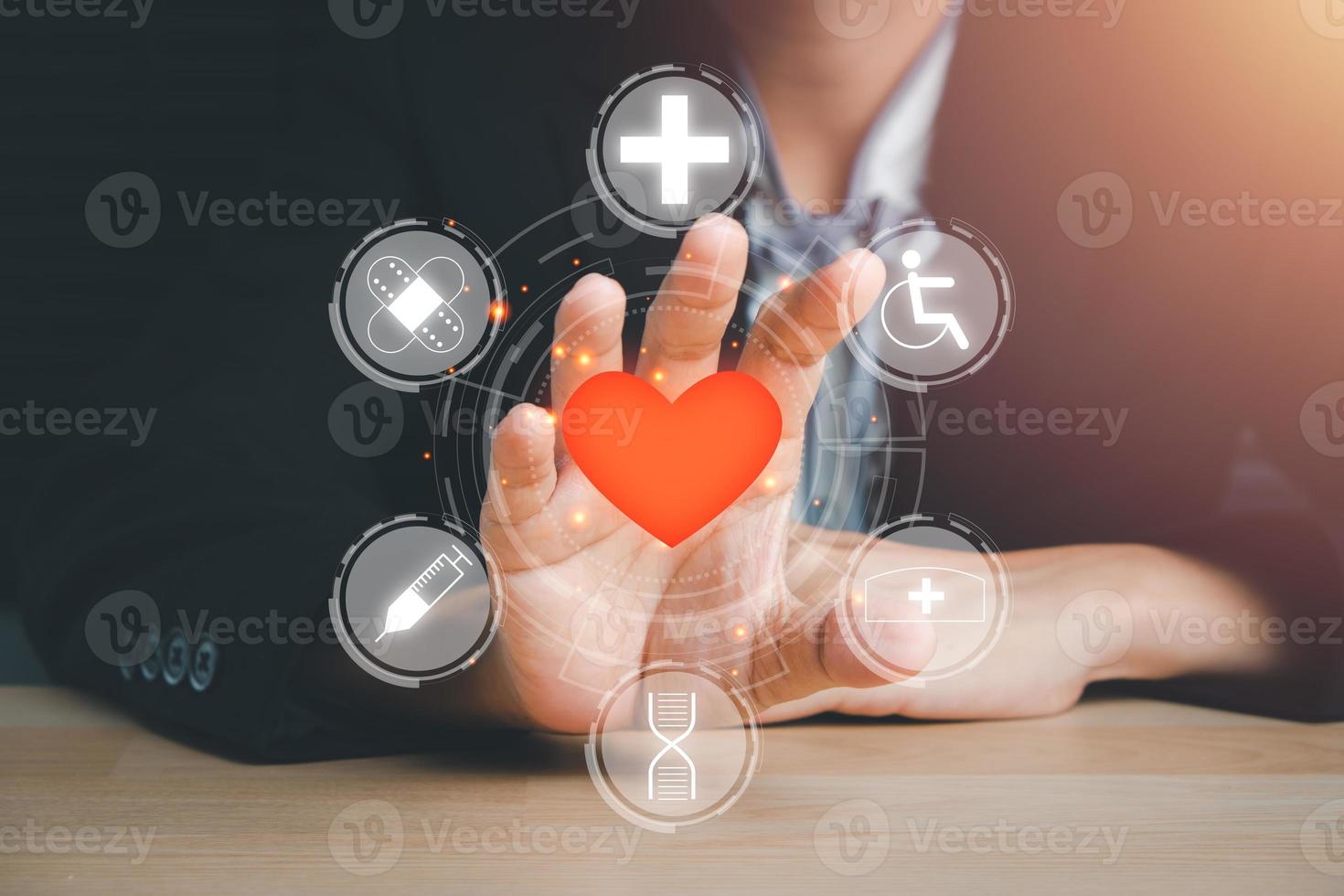 mano della persona che tiene l'icona del cuore rosso sullo schermo virtuale, assicurazione sanitaria del cuore, donazione di volontari di beneficenza, responsabilità csr, giornata mondiale del cuore, giornata mondiale della salute, giornata della famiglia, salvataggio di vite. foto