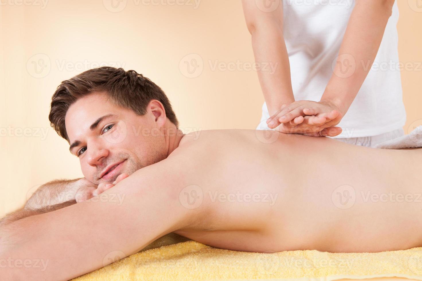 uomo che riceve massaggio alla schiena nella spa foto