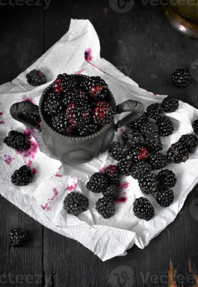 more appena raccolte in tazza antica con macchie di succo foto