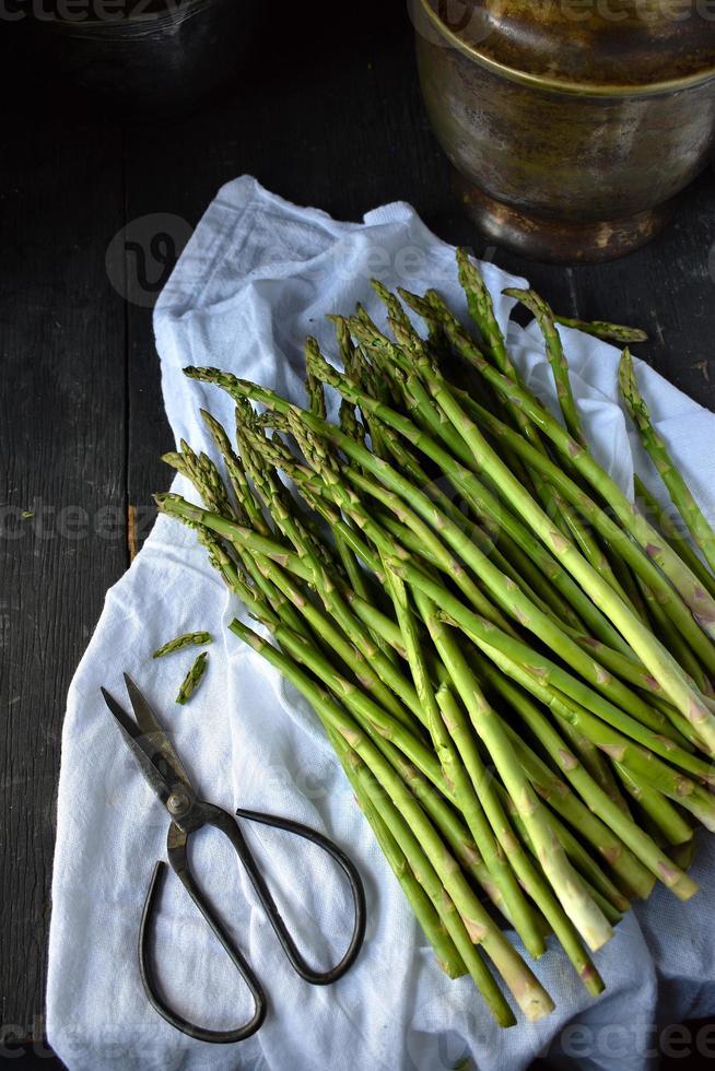 Fagotto di asparagi freschi in ambiente rustico di casale foto