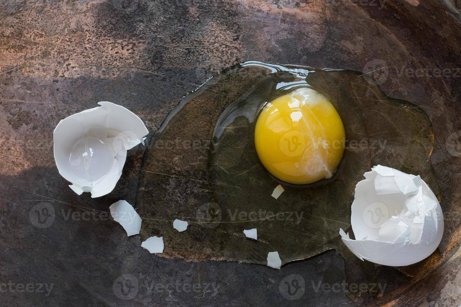 uovo bianco incrinato con vista dall'alto di tuorlo intero foto