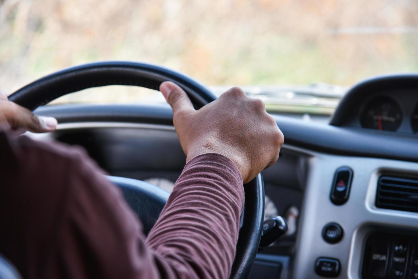 uomo che guida l'autista dell'auto mani sul volante che guida la mia macchina sulla strada foto