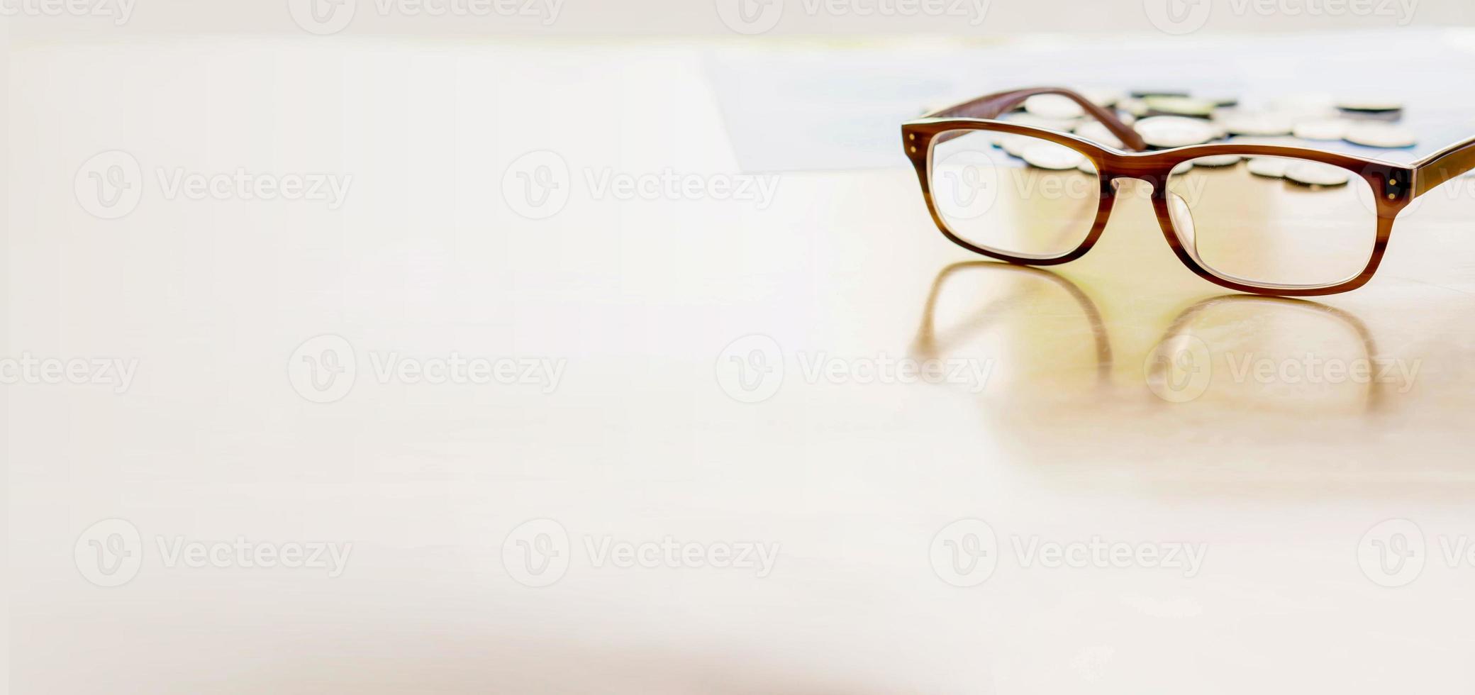 moneta degli occhiali sul tavolo foto