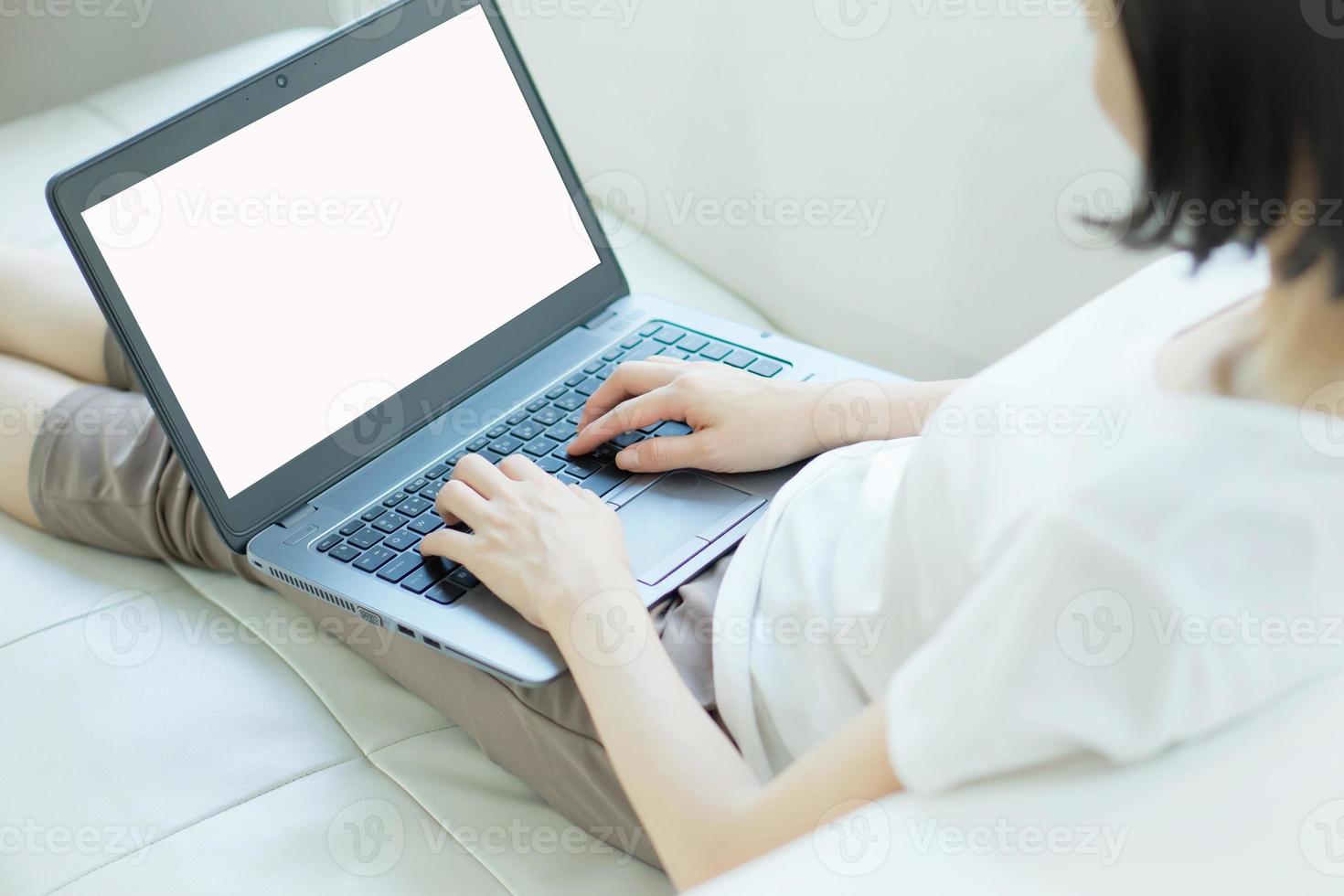 giovane donna casual che utilizza il computer portatile in soggiorno a casa foto
