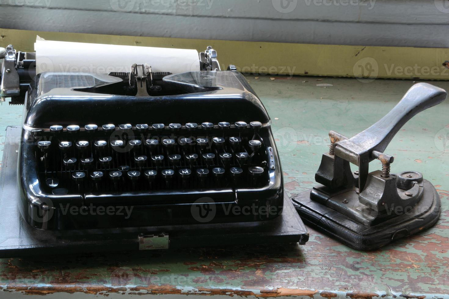 macchina da scrivere e perforatore su una scrivania foto