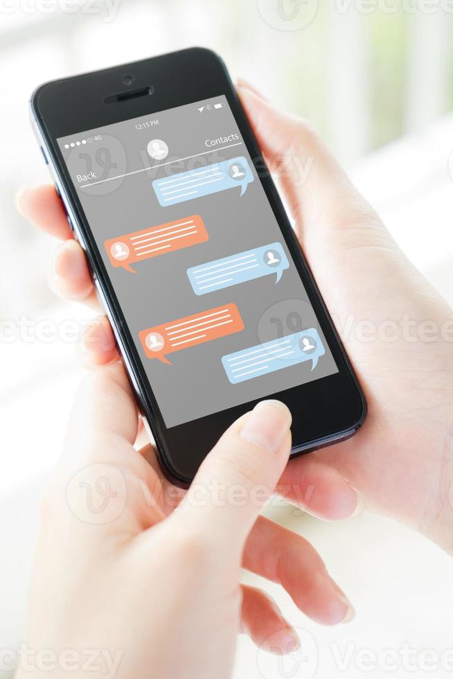 telefono della holding della mano della donna con il messaggero dell'app sullo schermo foto