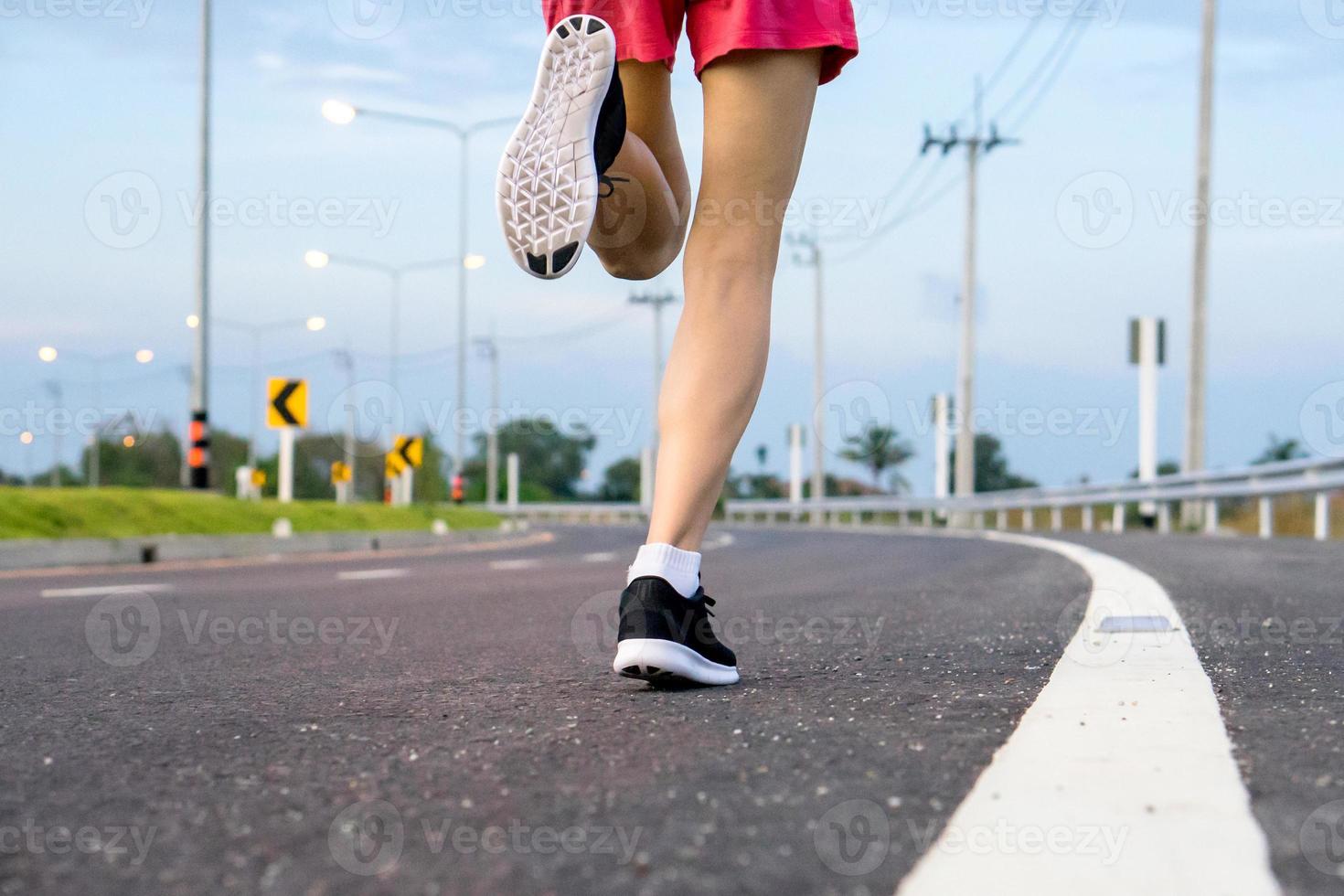 movimento. gambe di donna in esecuzione su strada asfaltata. foto