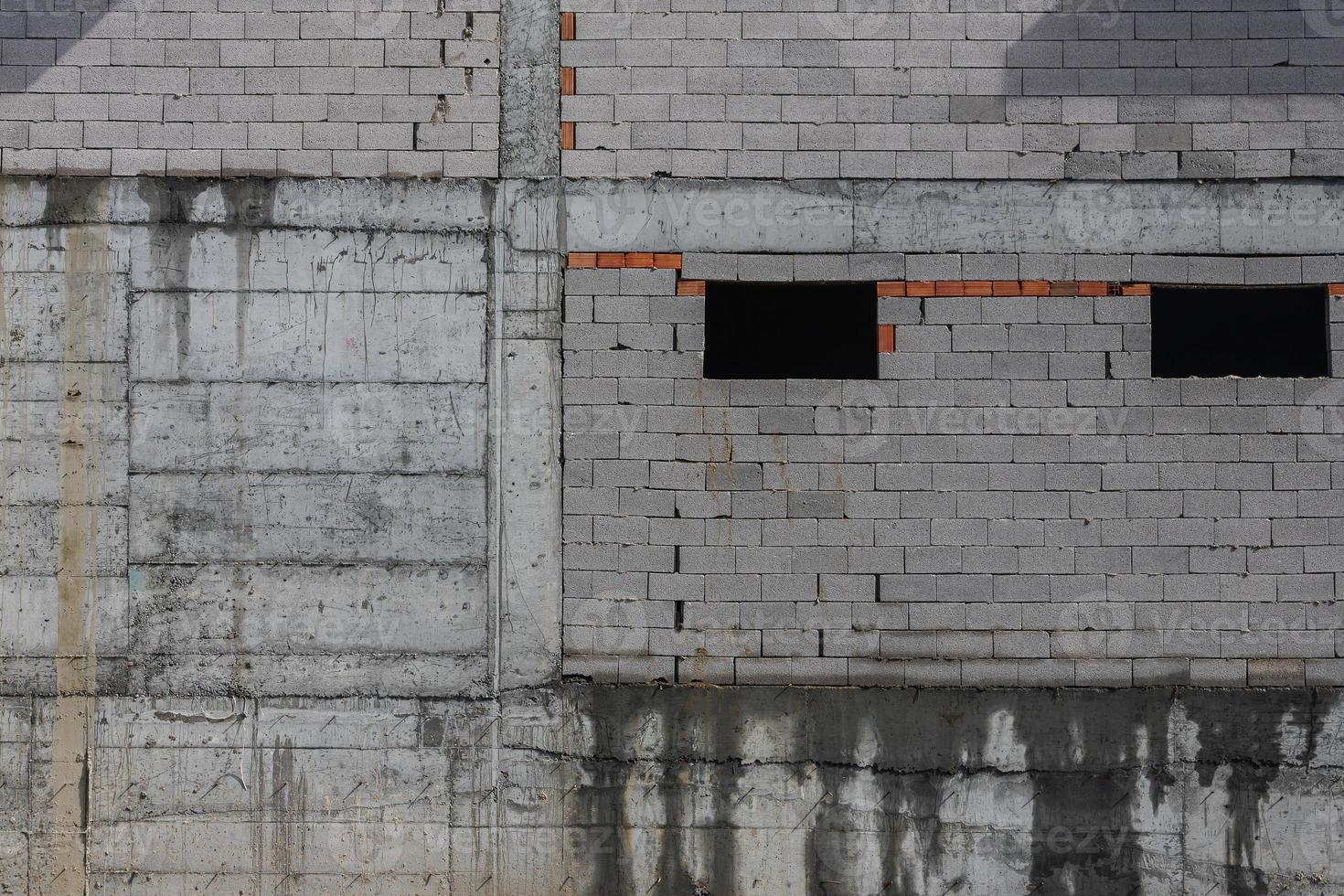 sfondo di muro di cemento in pietra grigia e marrone fatto di blocchi. struttura e sfondo della parete foto