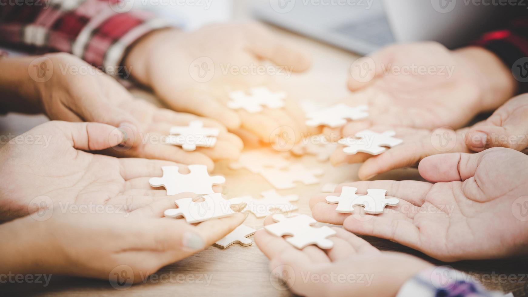 uomini d'affari e puzzle sulla tavola di legno foto
