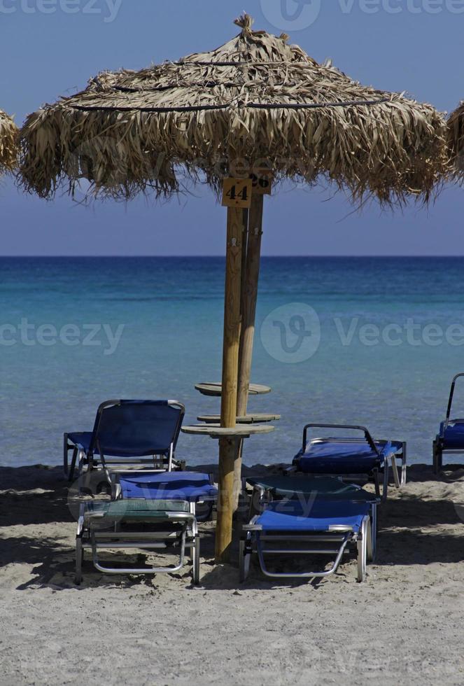 spiaggia vuota - ombrelloni e sedie a sdraio in attesa di turisti - spiaggia di elafonisi, creta foto