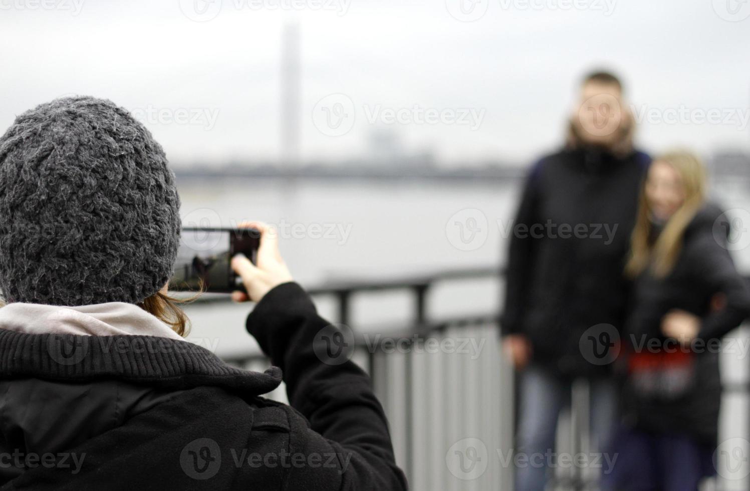 donna che scatta una foto di una coppia con il suo smartphone