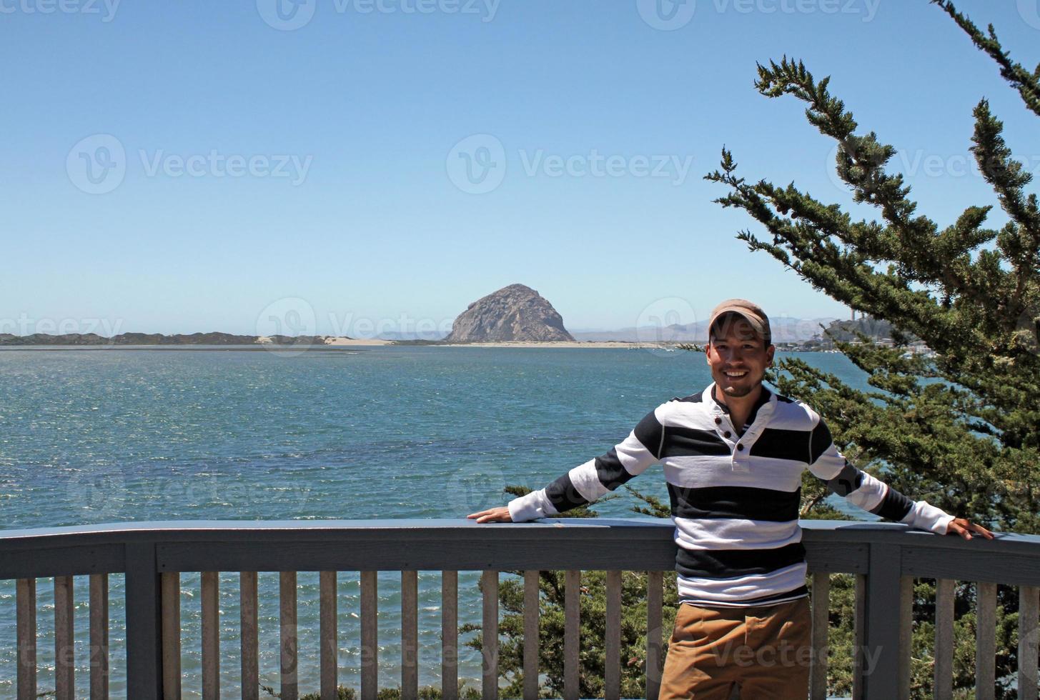 giovane con berretto da baseball in piedi vicino alla costa in california foto