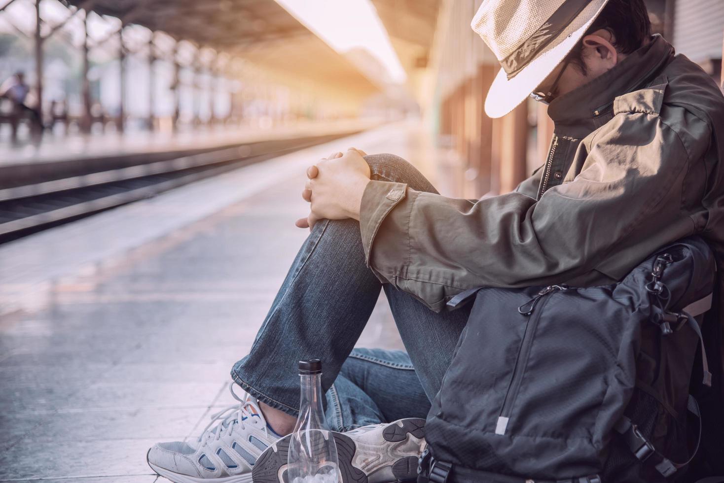 uomo di viaggio in attesa del treno alla piattaforma - attività di stile di vita di vacanza della gente al concetto di trasporto della stazione ferroviaria foto