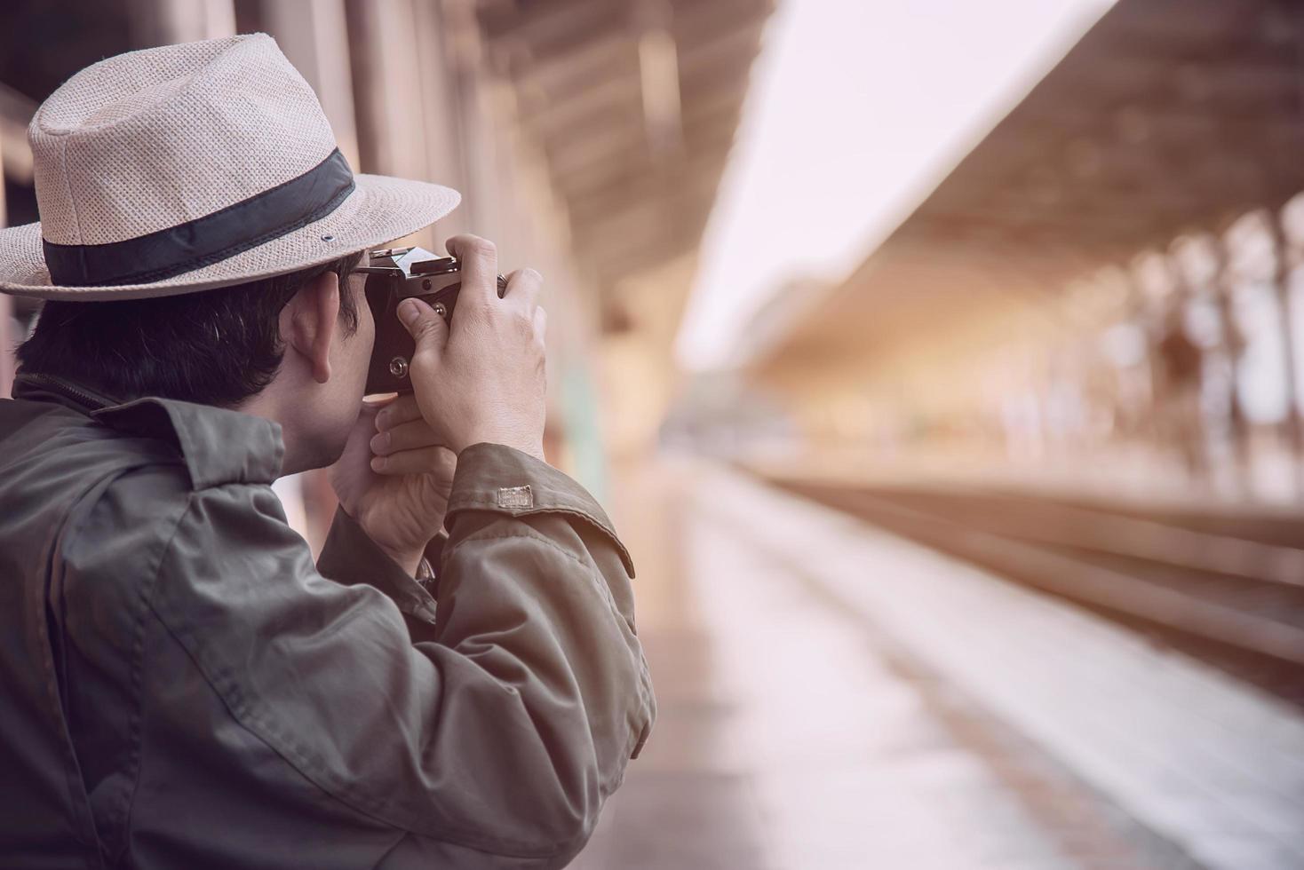 uomo di viaggio in attesa del treno alla piattaforma - attività di stile di vita di vacanza della gente al concetto di trasporto della stazione ferroviaria foto