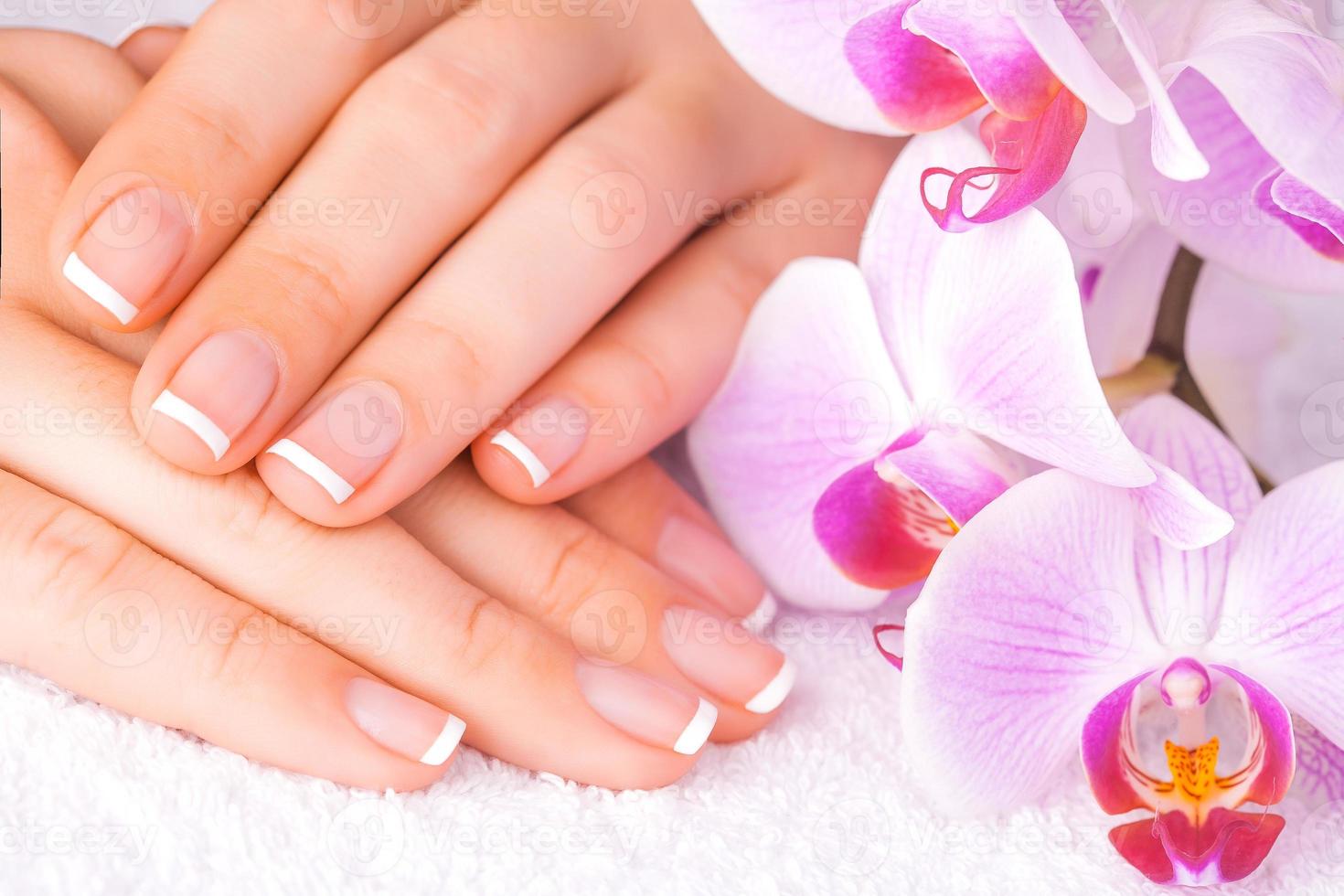bella manicure con orchidea rosa sul bianco foto