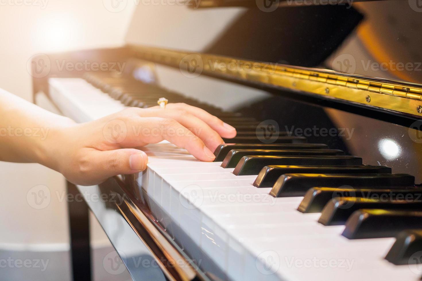 chiuda sulla mano del musicista che suona il pianoforte foto