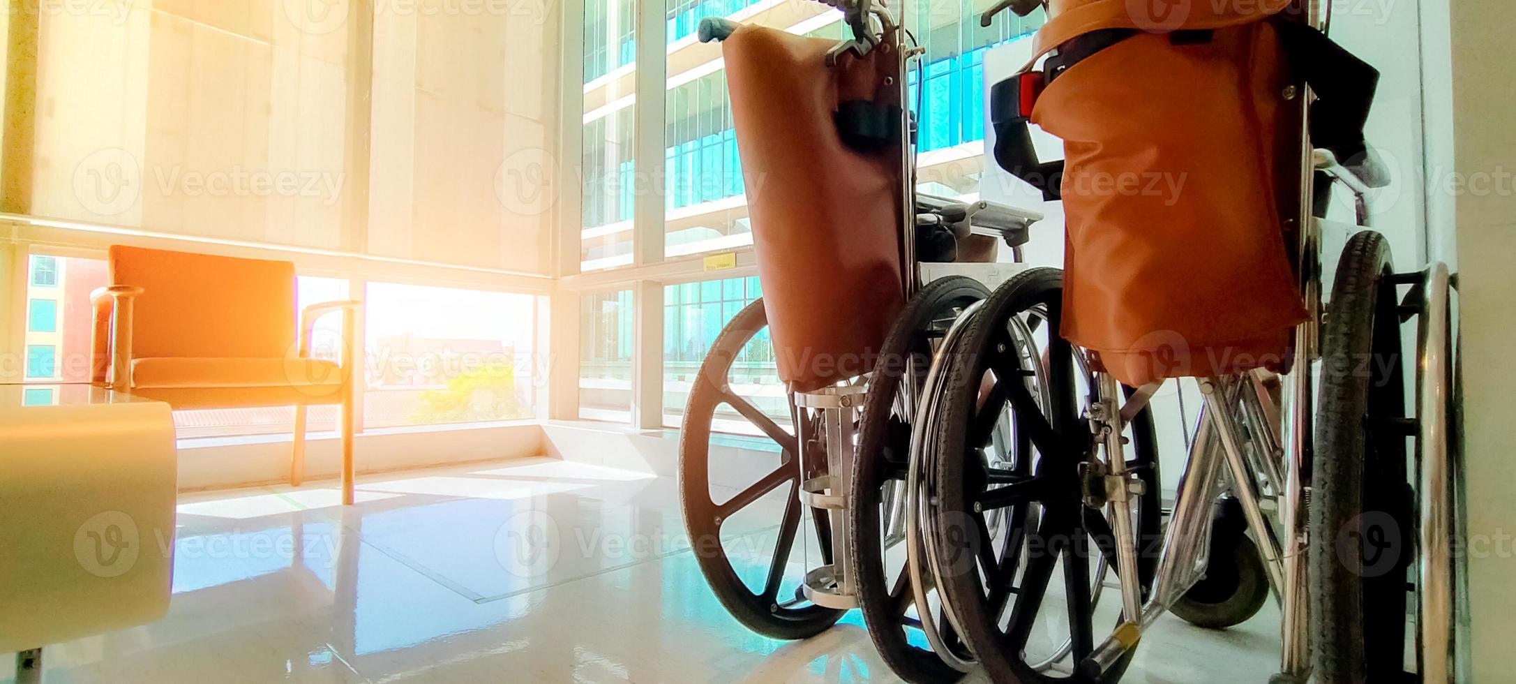 sedia a rotelle vuota in ospedale privato per pazienti di servizio e disabili. apparecchiature mediche in ospedale per l'assistenza agli anziani portatori di handicap. sedia con ruote per la cura del paziente in casa di cura. foto