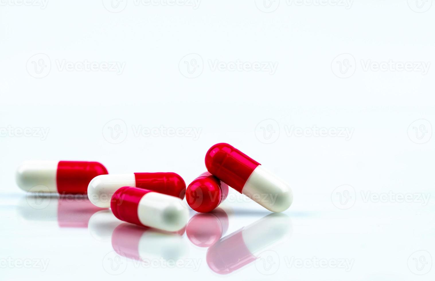 pillola rossa-bianca della capsula isolata su fondo bianco. resistenza ai farmaci antibiotici. capsule antimicrobiche. simbolo della farmacia della farmacia. industria farmaceutica. farmaci sanitari. foto