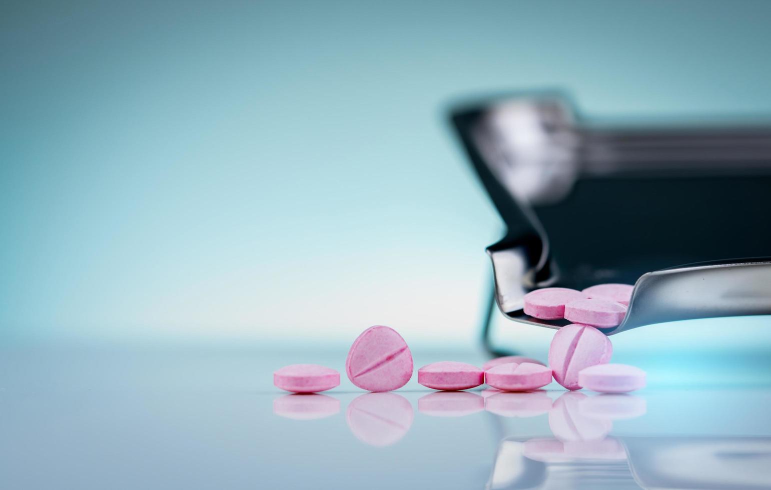 compresse rosa sul vassoio per farmaci in acciaio inossidabile. industria farmaceutica. vitamine neurotropiche. uso di farmaci in ospedale o in farmacia. mercato al dettaglio di farmaci. medicina per le neuropatie periferiche. foto