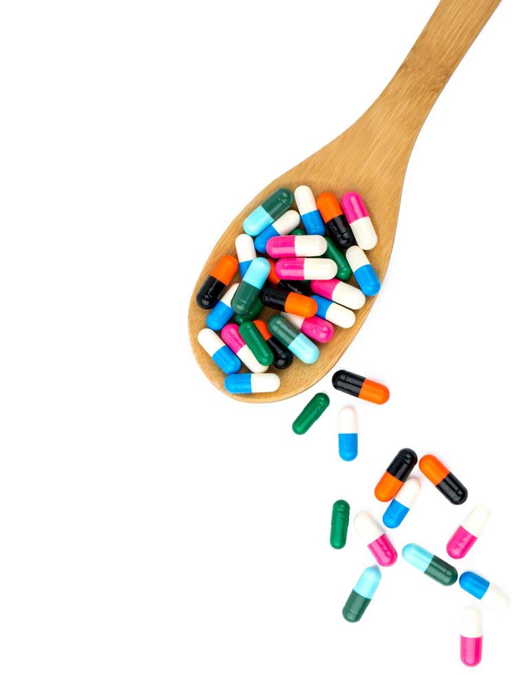 colorato di pillole di capsule antibiotiche e cucchiaio di legno. resistenza ai farmaci antibiotici. industria farmaceutica. sfondo farmacia farmacia. concetto di farmacia. uso eccessivo di farmaci antibiotici. assistenza sanitaria. foto