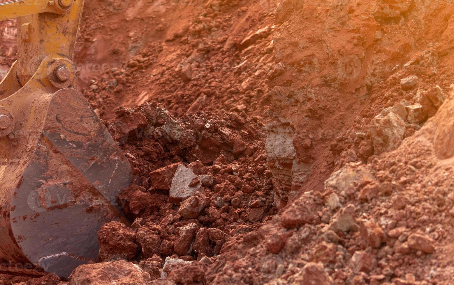 terne che lavorano scavando terreno in cantiere. secchio di terreno da scavo dell'escavatore a cucchiaia rovescia. escavatore cingolato che scava sullo sporco. secchio dell'escavatore a cucchiaia rovescia del primo piano di retroescavatore giallo. movimento terra. macchina per lo scavo. foto