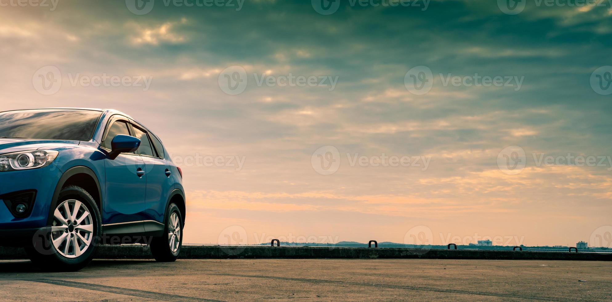 auto suv compatta blu con design sportivo e moderno parcheggiata su strada di cemento in riva al mare. concetto di tecnologia per auto ibride ed elettriche. posto auto. industria automobilistica. concetto di servizio di cura dell'auto. foto