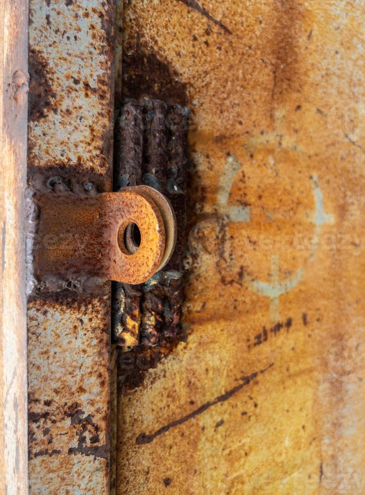 primo piano degli occhi arrugginiti del lucchetto sul cancello di metallo foto