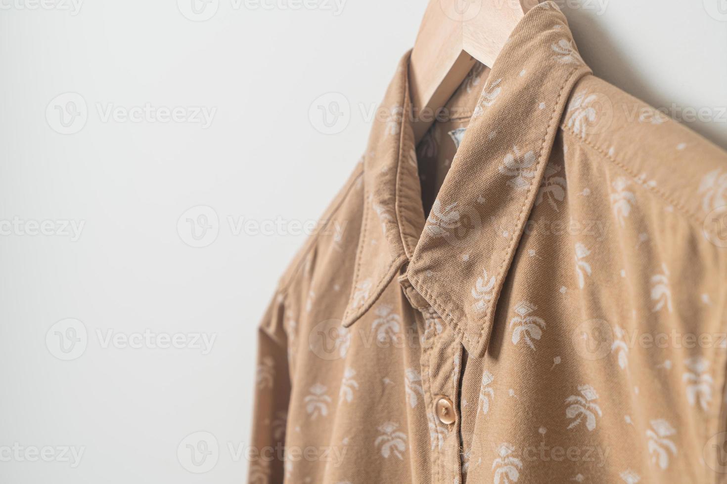 camicia appesa con appendiabiti in legno a parete foto