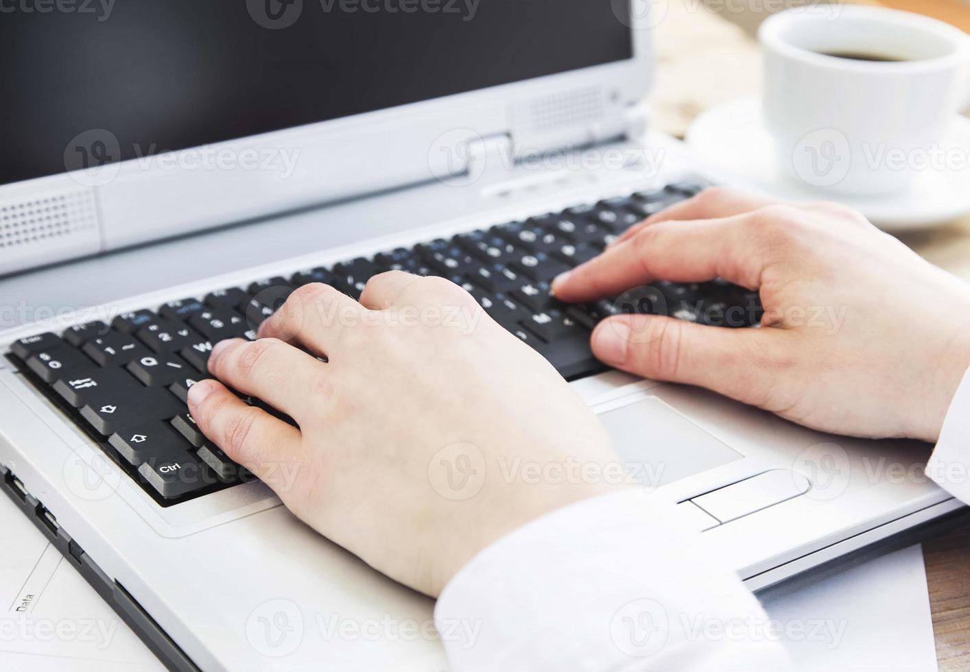 mani digitando sulla tastiera del computer in ufficio foto