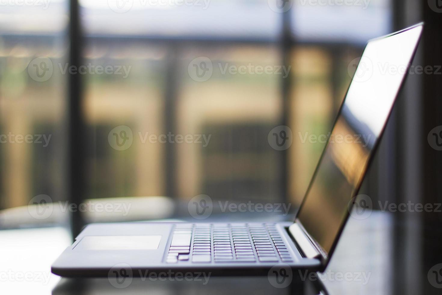 moderno computer portatile su un tavolo di vetro al tramonto foto