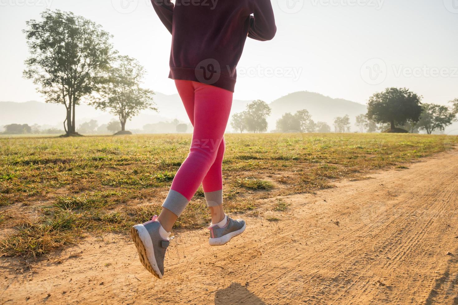 ragazza bambino felice che corre sul prato in estate in natura. bagliore di luce solare calda. il piccolo asiatico corre in un parco. sport all'aria aperta e fitness, esercizio fisico e apprendimento della competizione per lo sviluppo dei bambini. foto